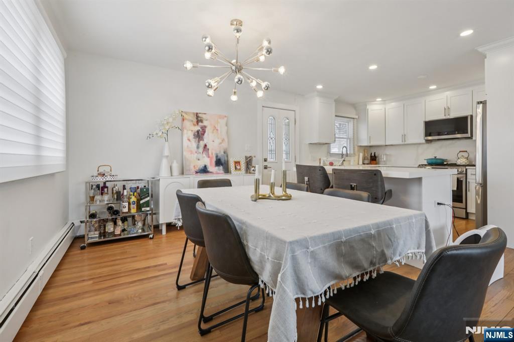10 Millo Place, Unit 1 Little Ferry, NJ 07643 - Photo 12 of 42 a large kitchen with kitchen island a dining table chairs and a refrigerator