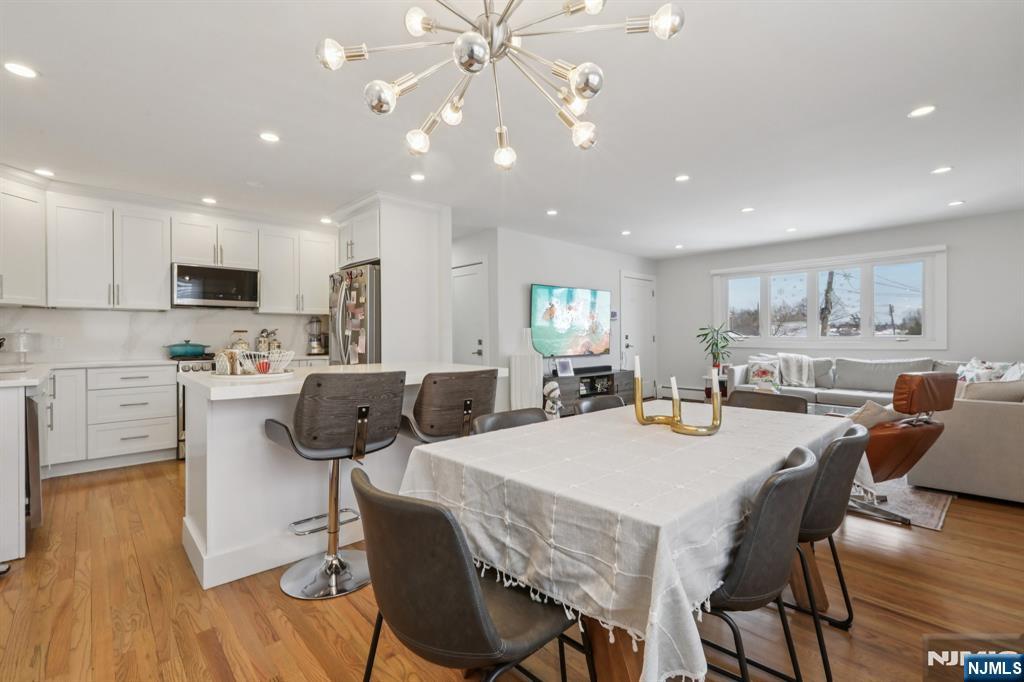 10 Millo Place, Unit 1 Little Ferry, NJ 07643 - Photo 14 of 42 a kitchen with a dining table chairs and wooden floor