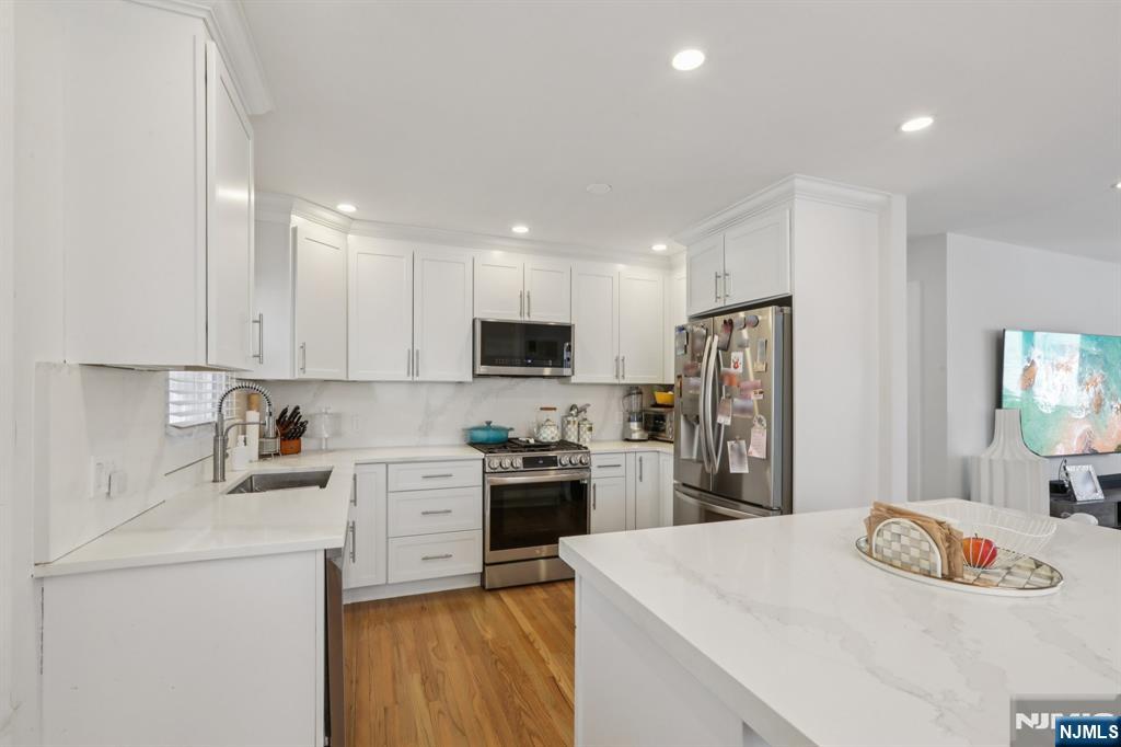 10 Millo Place, Unit 1 Little Ferry, NJ 07643 - Photo 16 of 42 a kitchen with a sink a stove and refrigerator