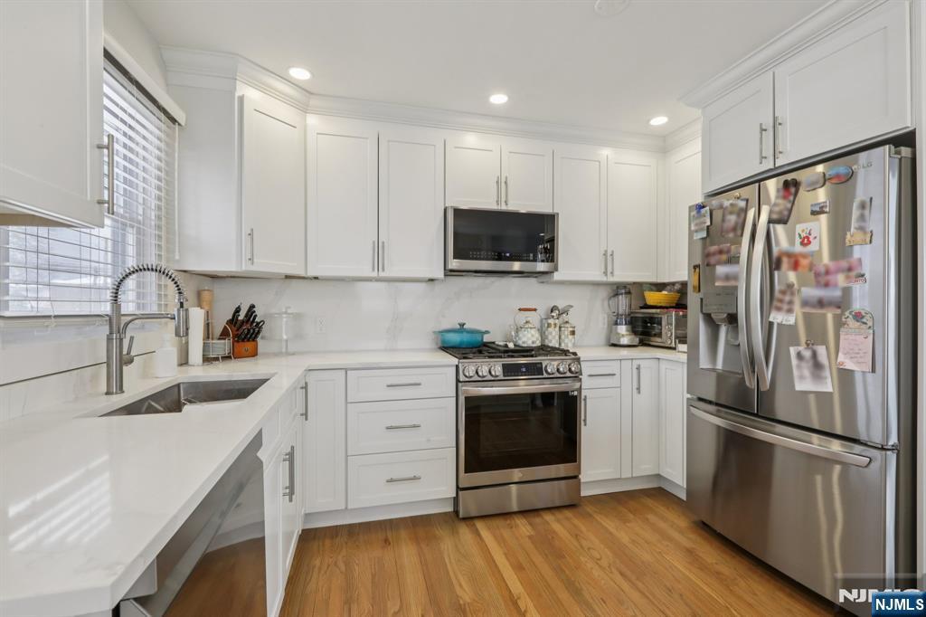 10 Millo Place, Unit 1 Little Ferry, NJ 07643 - Photo 18 of 42 a kitchen with a refrigerator stove and sink