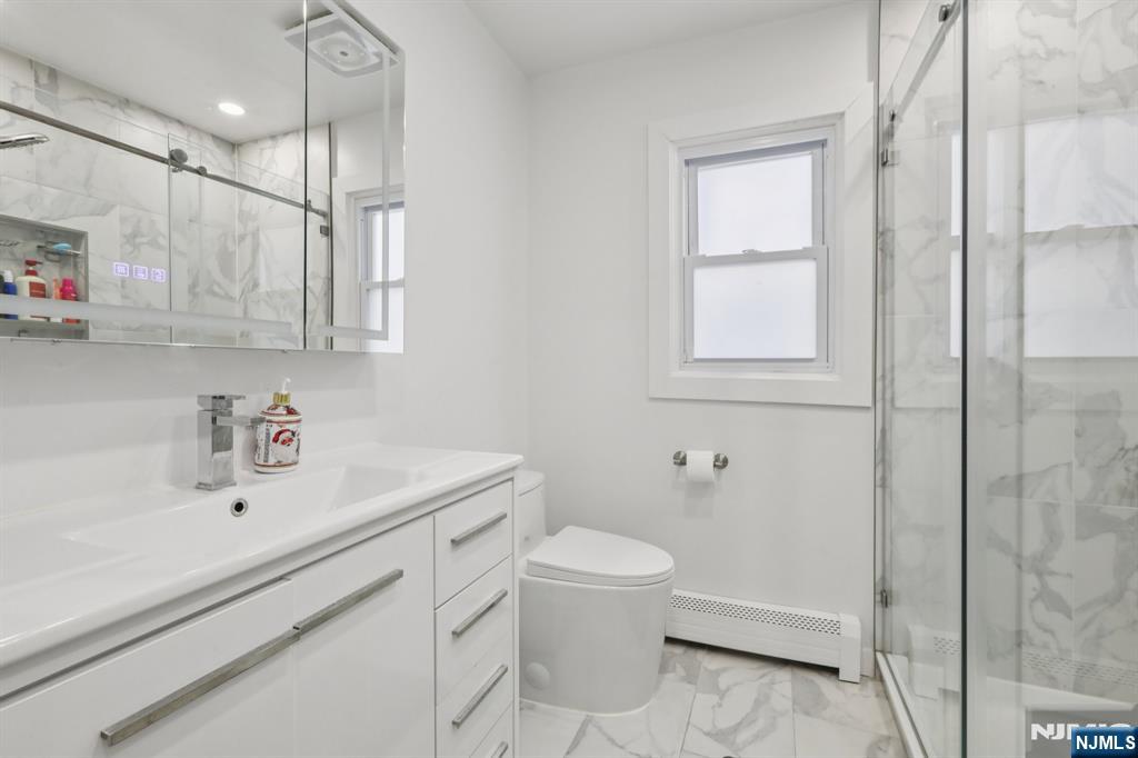 10 Millo Place, Unit 1 Little Ferry, NJ 07643 - Photo 21 of 42 a bathroom with a sink a toilet and shower