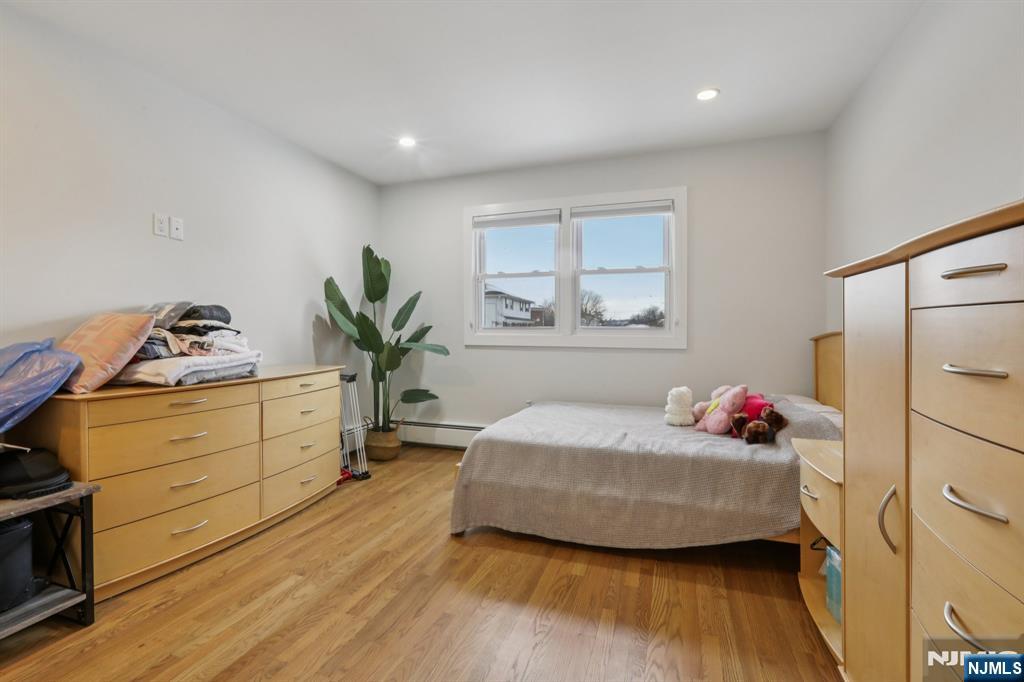 10 Millo Place, Unit 1 Little Ferry, NJ 07643 - Photo 25 of 42 a bedroom with a bed and wooden floor