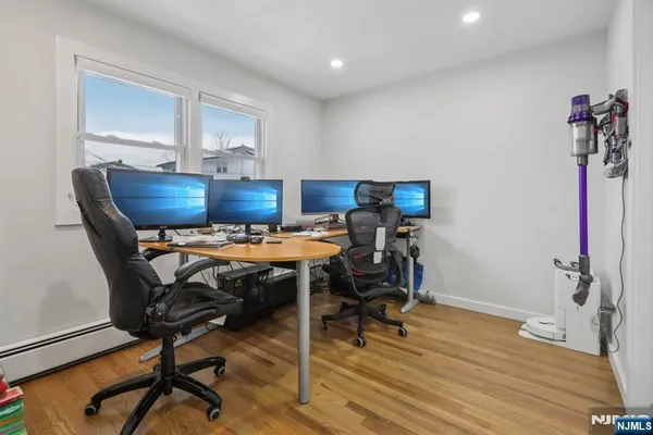 a view of a workspace with furniture and wooden floor