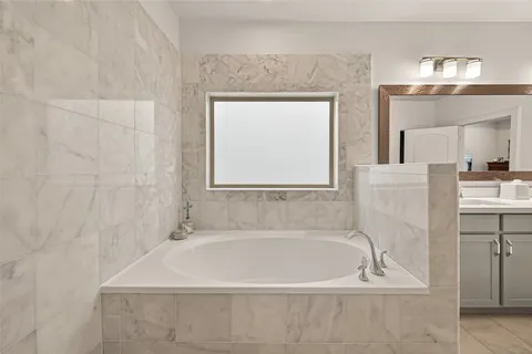 a white bath tub sitting next to a white sink