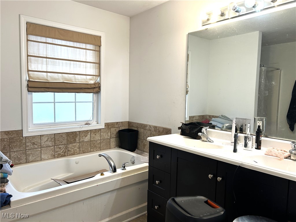 5320 Boston Road Brunswick, OH 44212 - Photo 12 of 18 Owner's bathroom with double sink vanity, a bath, and a shower
