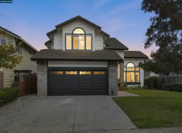 a front view of a house with a yard and garage