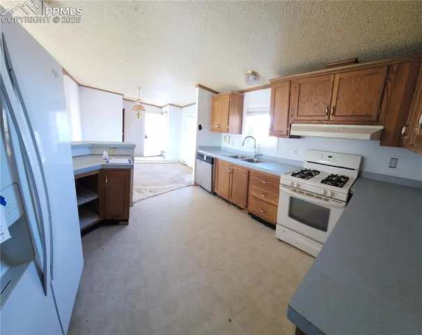 a kitchen with stainless steel appliances a stove a sink and a refrigerator
