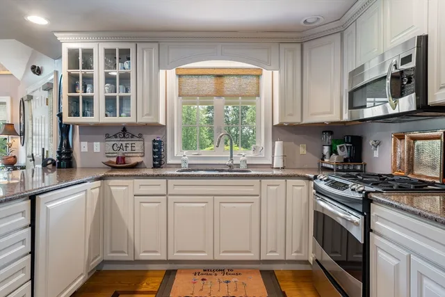 a kitchen with stainless steel appliances granite countertop a stove a sink and a microwave