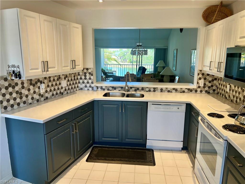 185 Gabriel Circle, Unit 4 Naples, FL 34104 - Photo 3 of 20 a kitchen with a sink stove and cabinets