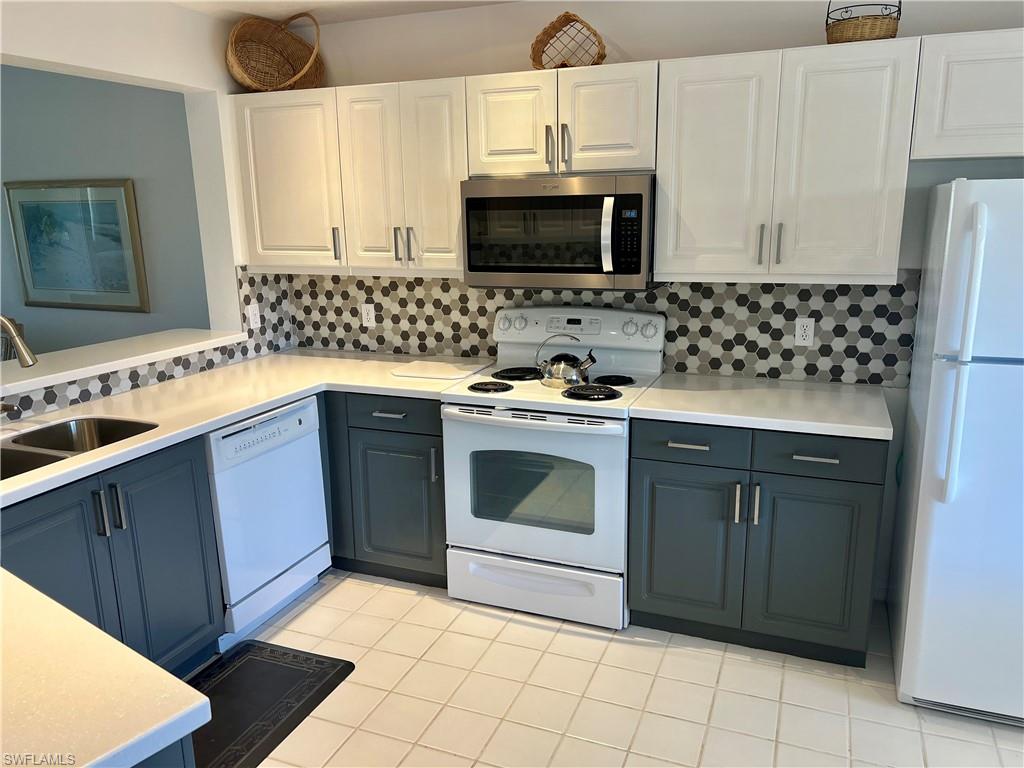 185 Gabriel Circle, Unit 4 Naples, FL 34104 - Photo 4 of 20 a kitchen with a sink stove and microwave