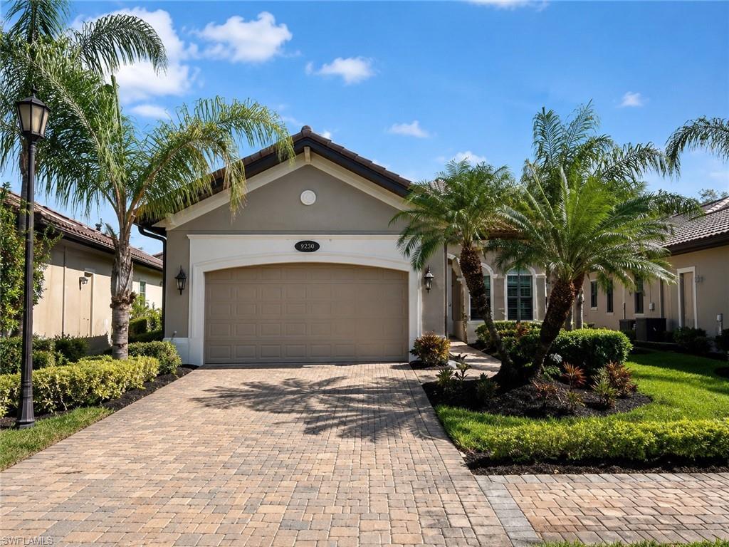 6574 Amarone Lane Naples, FL 34113 - Photo 2 of 44 a front view of a house with a yard