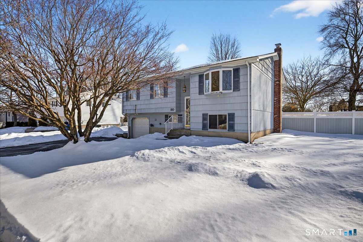 a front view of a house with a yard covered in snow