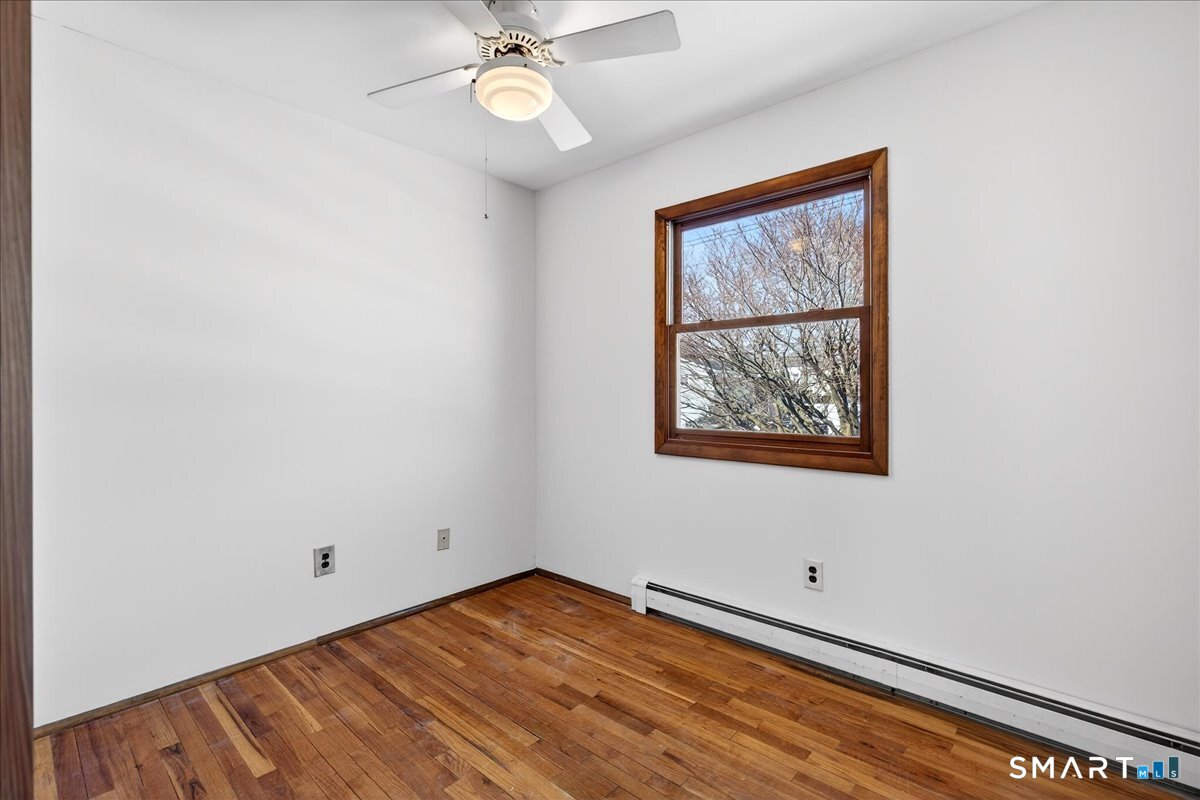 80 Flower Drive Hamden, CT 06518 - Photo 15 of 28 a view of an empty room with a window and wooden floor