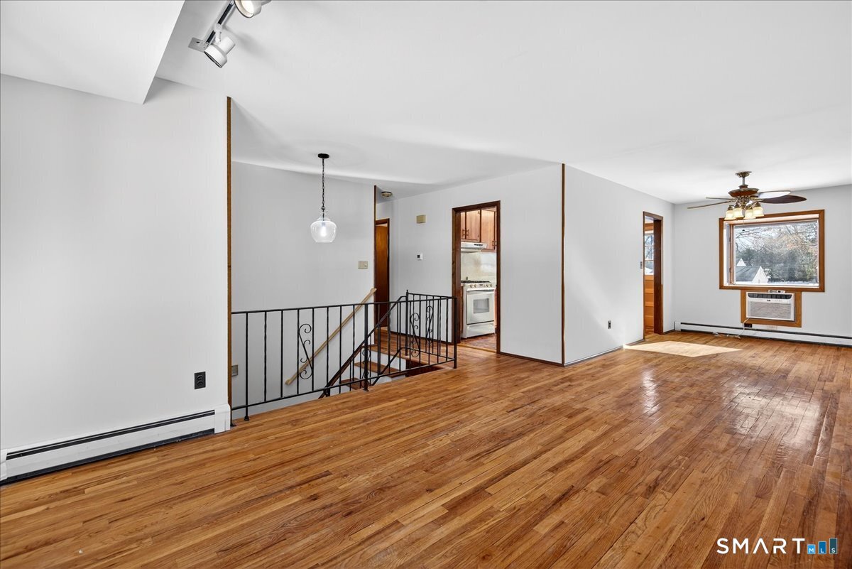 80 Flower Drive Hamden, CT 06518 - Photo 4 of 28 a view of a room with wooden floor stairs and a large window
