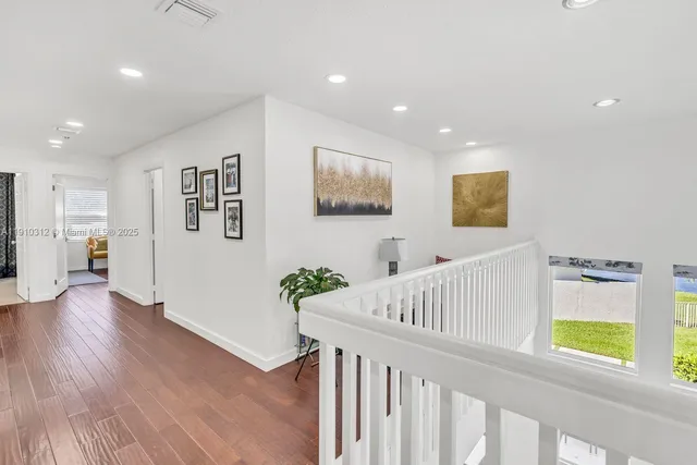 a patio with tables and chairs under an umbrella