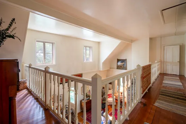 a view of staircase with lots of frames on wall and a window