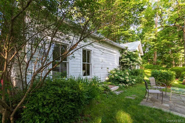 a white house that has a tree in front of it