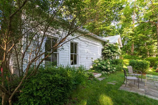 a white house that has a tree in front of it