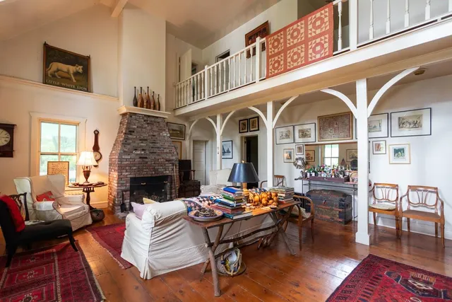 a living room with furniture dining table a rug and a fireplace