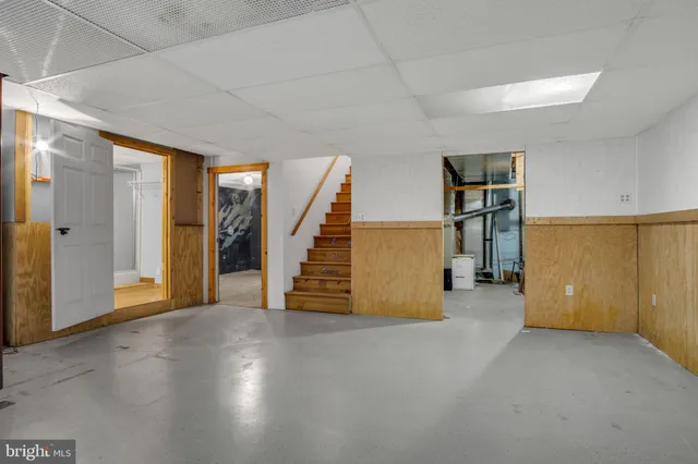 an empty room with wooden floor and stairs