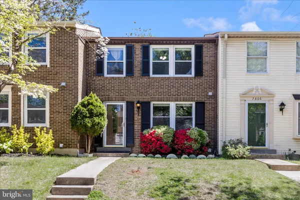 front view of a brick house with a yard