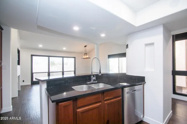a kitchen with granite countertop a sink stove and cabinets