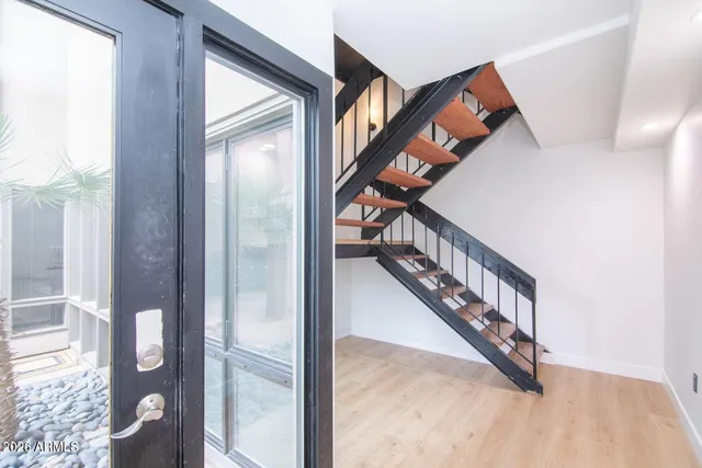 a view of staircase with lots of frames on wall and a large window