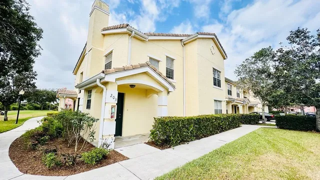 a view of a white house with a yard and potted plants