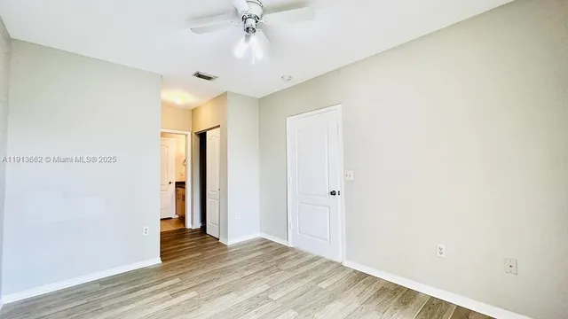 a view of an empty room with wooden floor