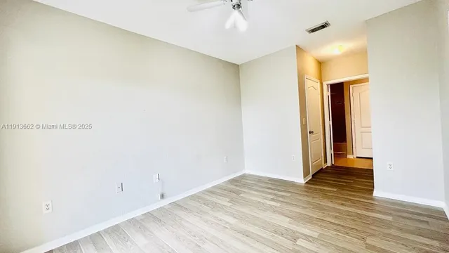 a view of an empty room with wooden floor