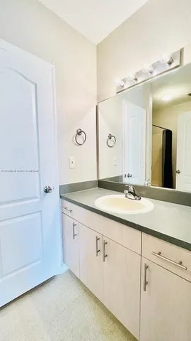 a bathroom with a granite countertop sink and a mirror