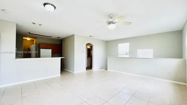 a view of a livingroom with a ceiling fan and window