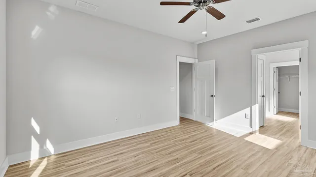a view of hallway with window and wooden floor