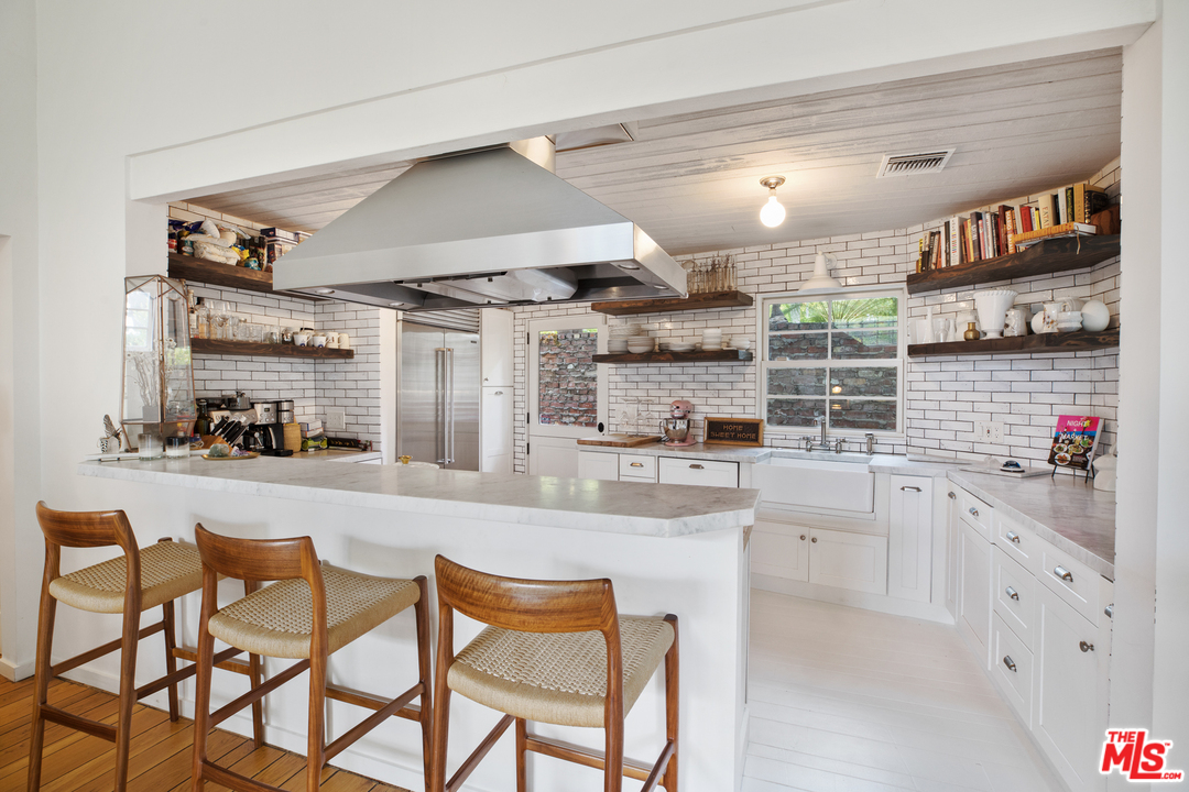 558 East Channel Road Santa Monica, CA 90402 - Photo 12 of 34 a kitchen with stainless steel appliances kitchen island granite countertop a sink and cabinets