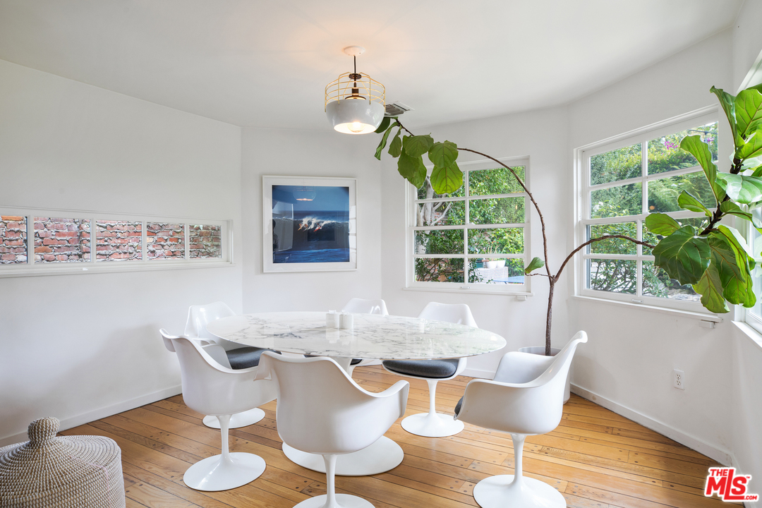 558 East Channel Road Santa Monica, CA 90402 - Photo 14 of 34 a dining room with wooden floor a chandelier a glass table and chairs