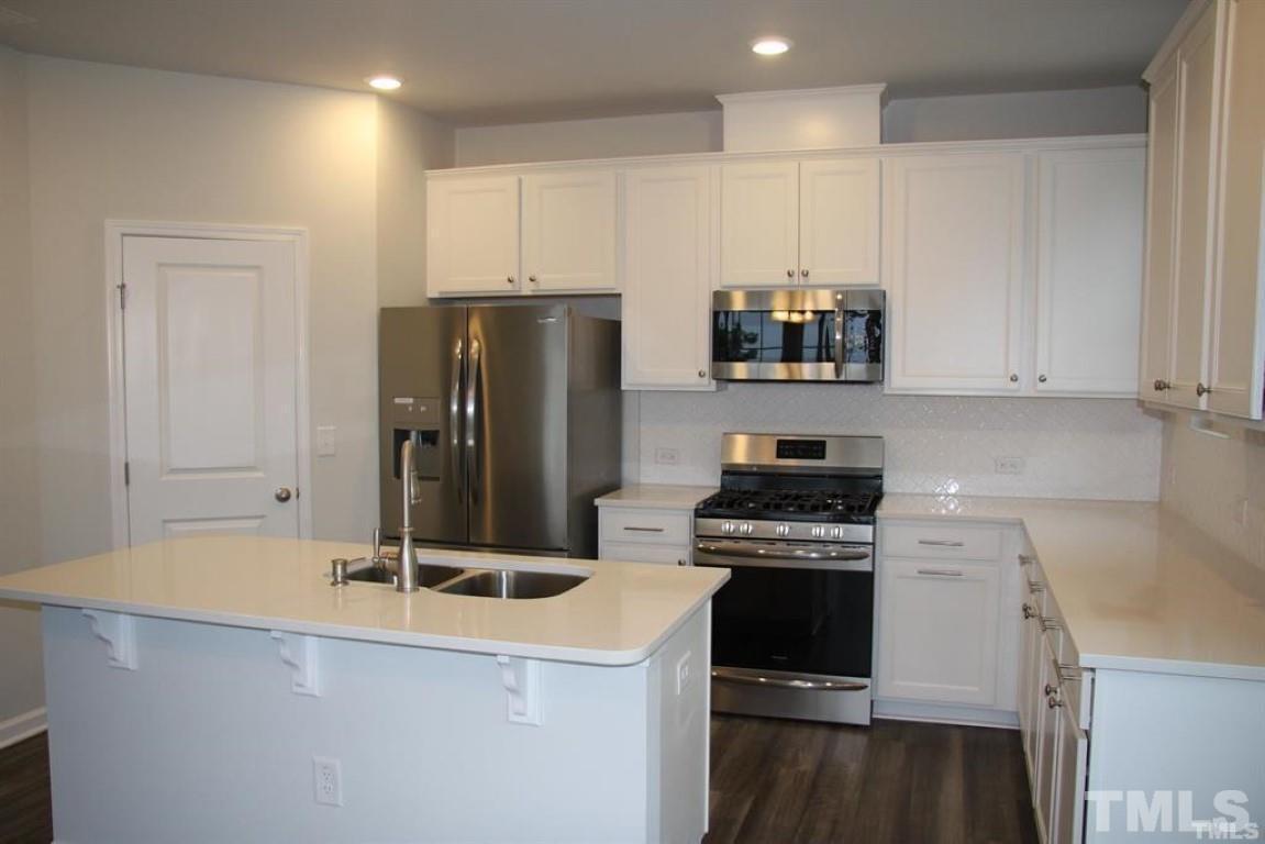 2919 Sunflower Road Apex, NC 27502 - Photo 15 of 34 a kitchen with a refrigerator and a sink