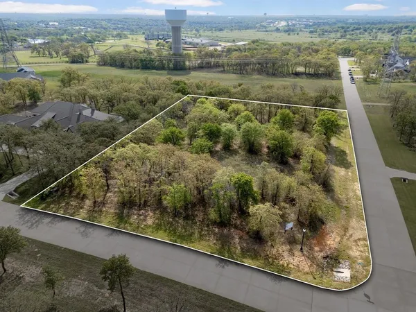 an aerial view of residential houses with outdoor space and trees