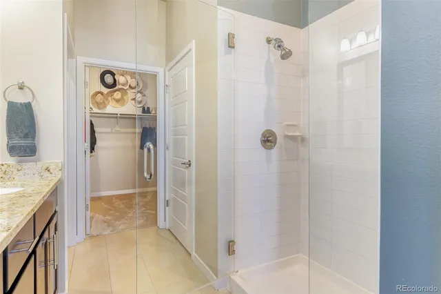 a bathroom with a granite countertop shower a mirror and a shower