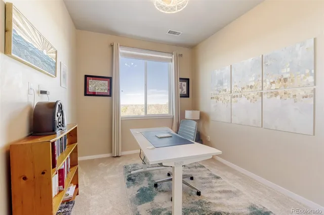 a view of a workspace with furniture and a window