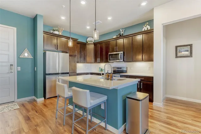 a kitchen with kitchen island stainless steel appliances a sink stove and refrigerator