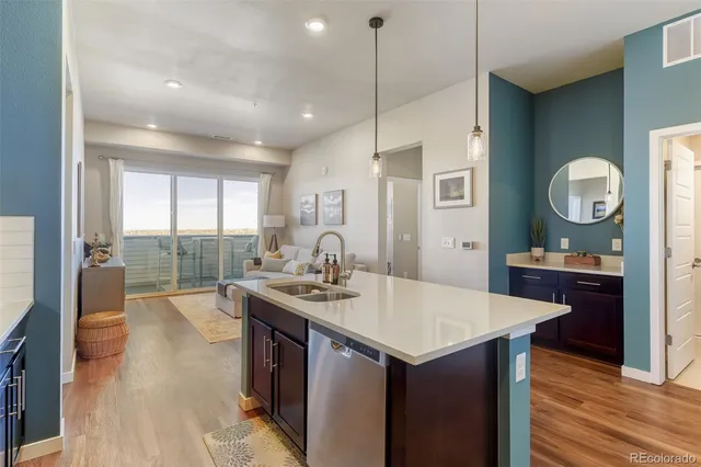 a kitchen with a stove a sink a counter space and wooden floor