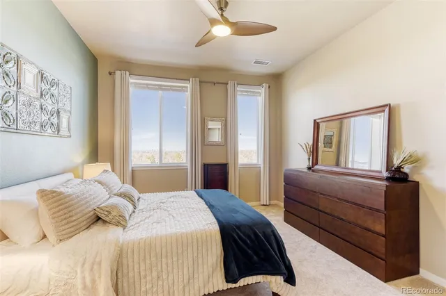 a bedroom with a large bed and windows