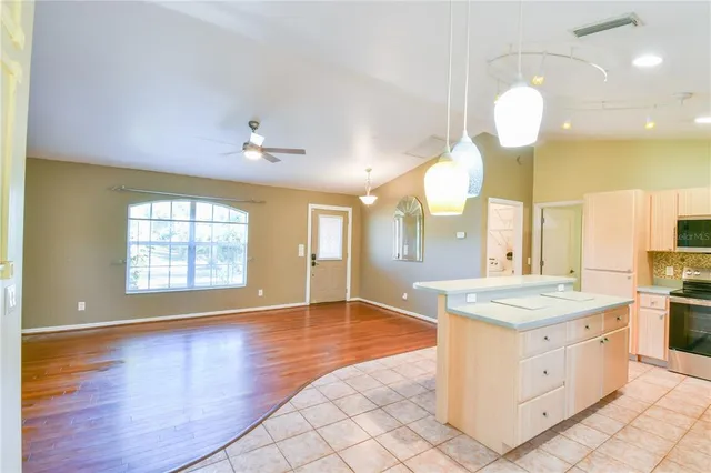 a kitchen with stainless steel appliances granite countertop a refrigerator a stove and a sink