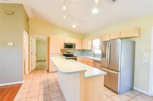 a large kitchen with kitchen island a sink stainless steel appliances and cabinets