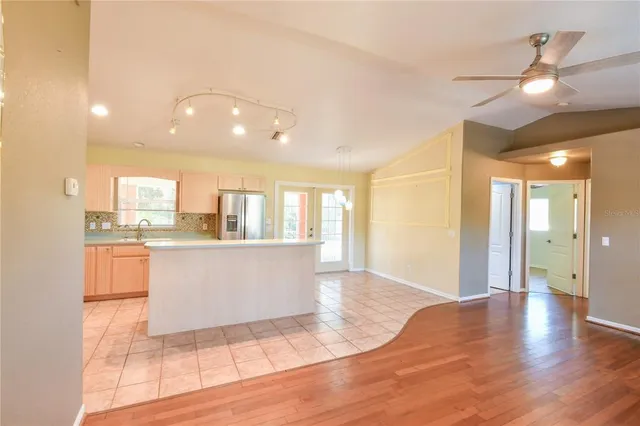 a view of kitchen with stainless steel appliances refrigerator stove and kitchen island