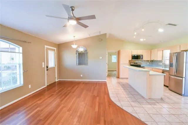 a view of an empty room with window and wooden floor