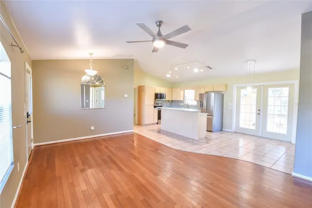 a view of an empty room with window and wooden floor