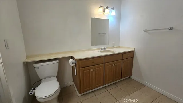 a bathroom with a granite countertop toilet sink and mirror
