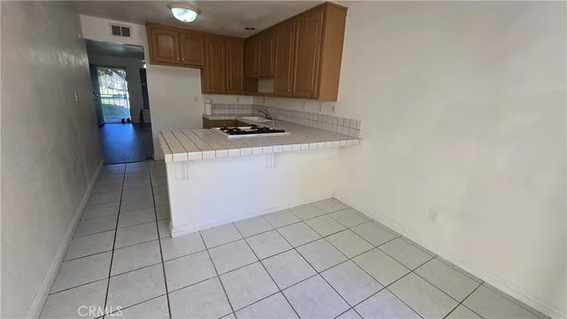 a kitchen with white cabinets a refrigerator and a stove