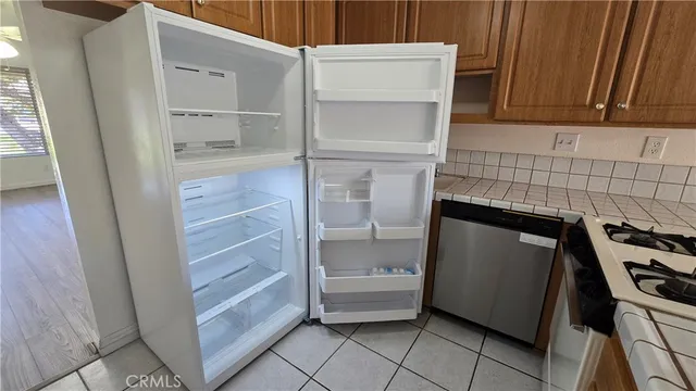 a kitchen with white cabinets and a refrigerator